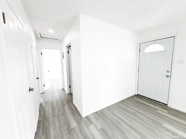 an empty room with wooden floor and a bathroom