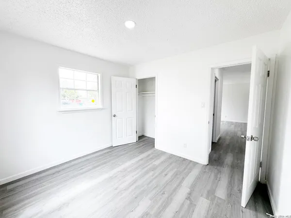 an empty room with wooden floor and a window