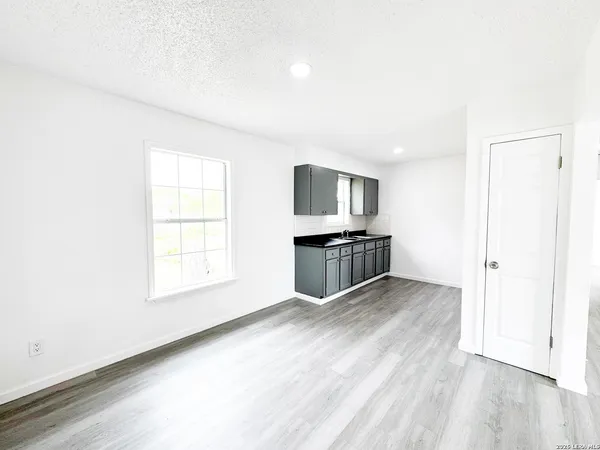 an empty room with wooden floor and white walls