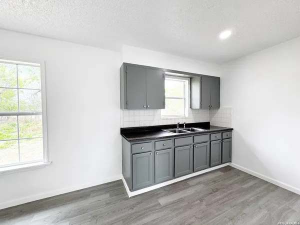 a kitchen with granite countertop a stove a sink and a window