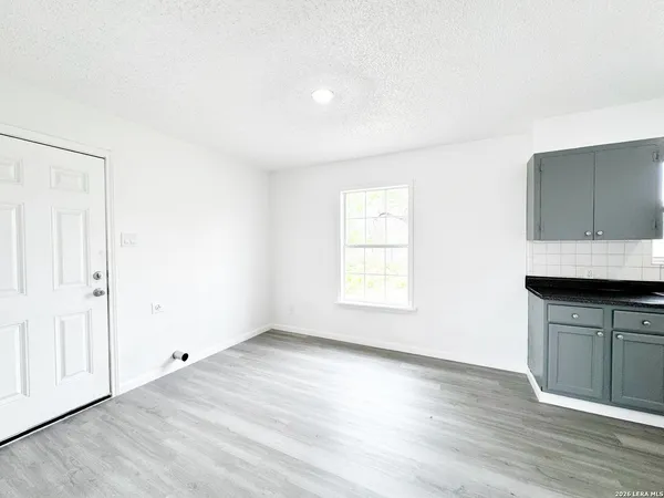 an empty room with wooden floor and cabinet