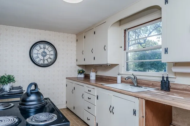 a kitchen with a large clock and cabinets