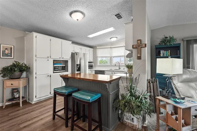 a kitchen with stainless steel appliances a table and chairs in it