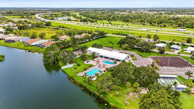 a view of a swimming pool with a lounge chair and dinning table under an umbrella