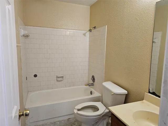 an empty room with a window and a ceiling fan