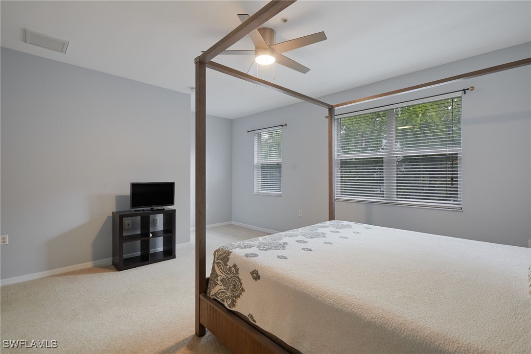 4381 Lazio Way, Unit 504 Fort Myers, FL 33901 - Photo 11 of 21 a bedroom with a bed and a large window