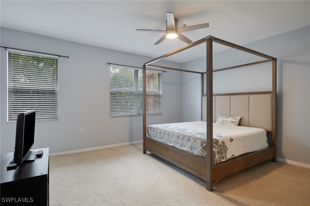4381 Lazio Way, Unit 504 Fort Myers, FL 33901 - Photo 12 of 21 a bed sitting in a bedroom next to a window