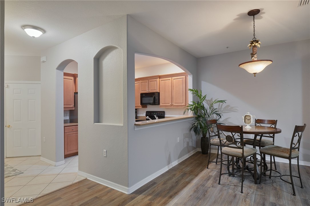 4381 Lazio Way, Unit 504 Fort Myers, FL 33901 - Photo 3 of 21 a view of a dining room with furniture and wooden floor