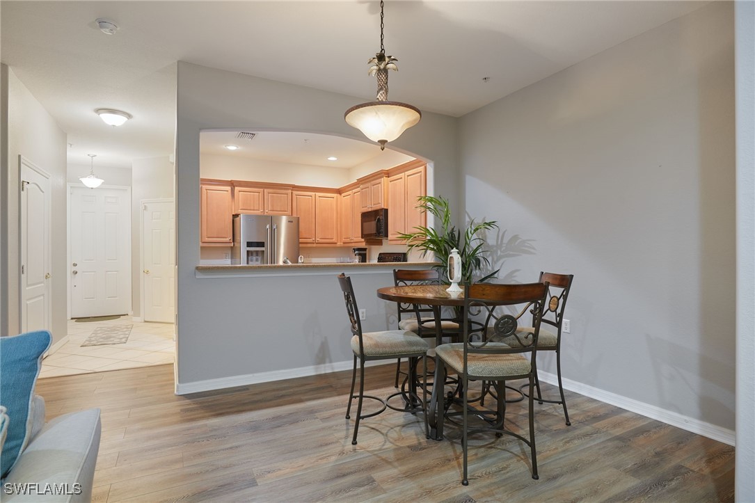 4381 Lazio Way, Unit 504 Fort Myers, FL 33901 - Photo 4 of 21 a view of a dining room with furniture and wooden floor