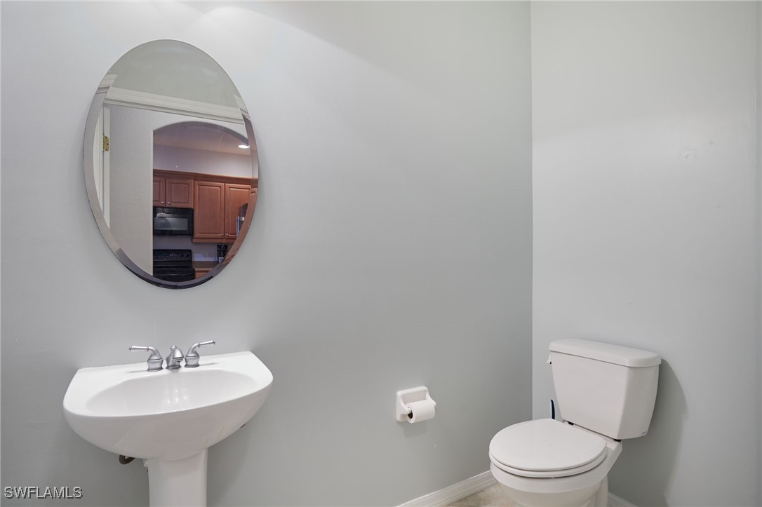 4381 Lazio Way, Unit 504 Fort Myers, FL 33901 - Photo 9 of 21 a bathroom with a toilet sink and mirror