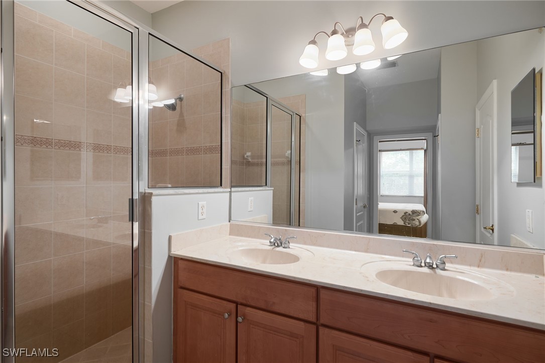 4381 Lazio Way, Unit 504 Fort Myers, FL 33901 - Photo 10 of 21 a bathroom with a double vanity sink and a mirror