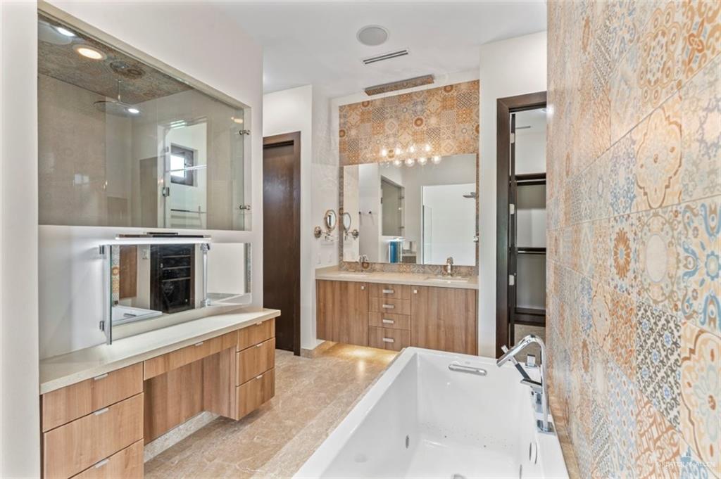 1425 Encanto Road, Unit SERVICE Weslaco, TX 78596 - Photo 16 of 45 Bathroom with vanity, a freestanding tub, tile walls, and a shower