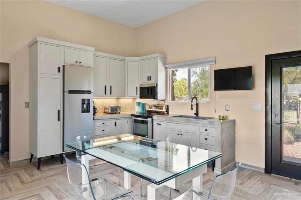 1425 Encanto Road, Unit SERVICE Weslaco, TX 78596 - Photo 41 of 45 Kitchen with white cabinetry, stainless steel appliances, and decorative backsplash