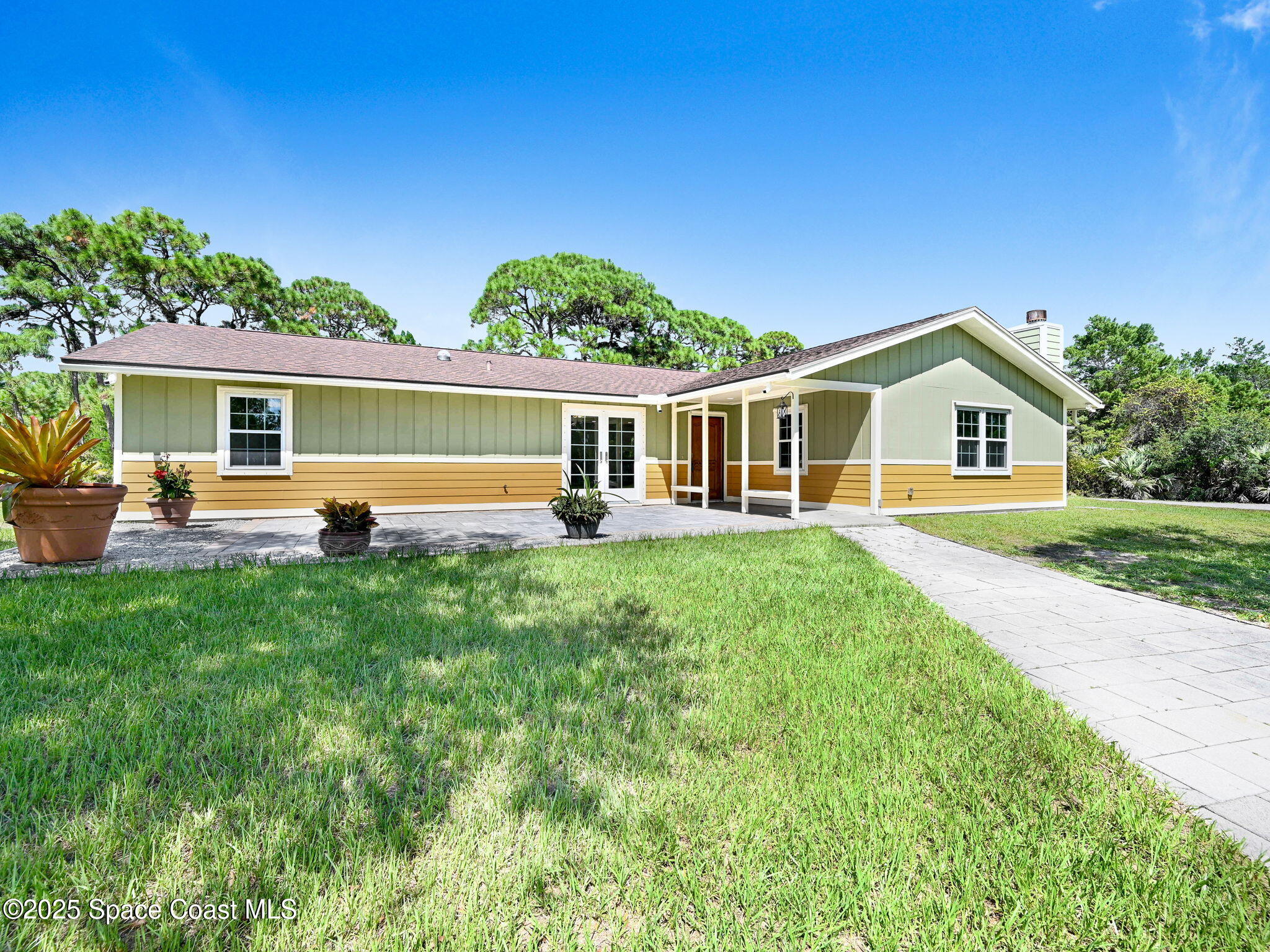 6570 Whispering Pines Lane Grant, FL 32949 - Photo 11 of 62 a front view of a house with garden