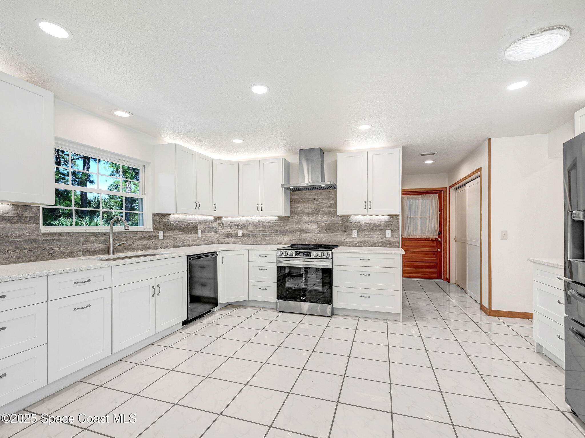 6570 Whispering Pines Lane Grant, FL 32949 - Photo 28 of 62 a kitchen with a stove a sink and a refrigerator
