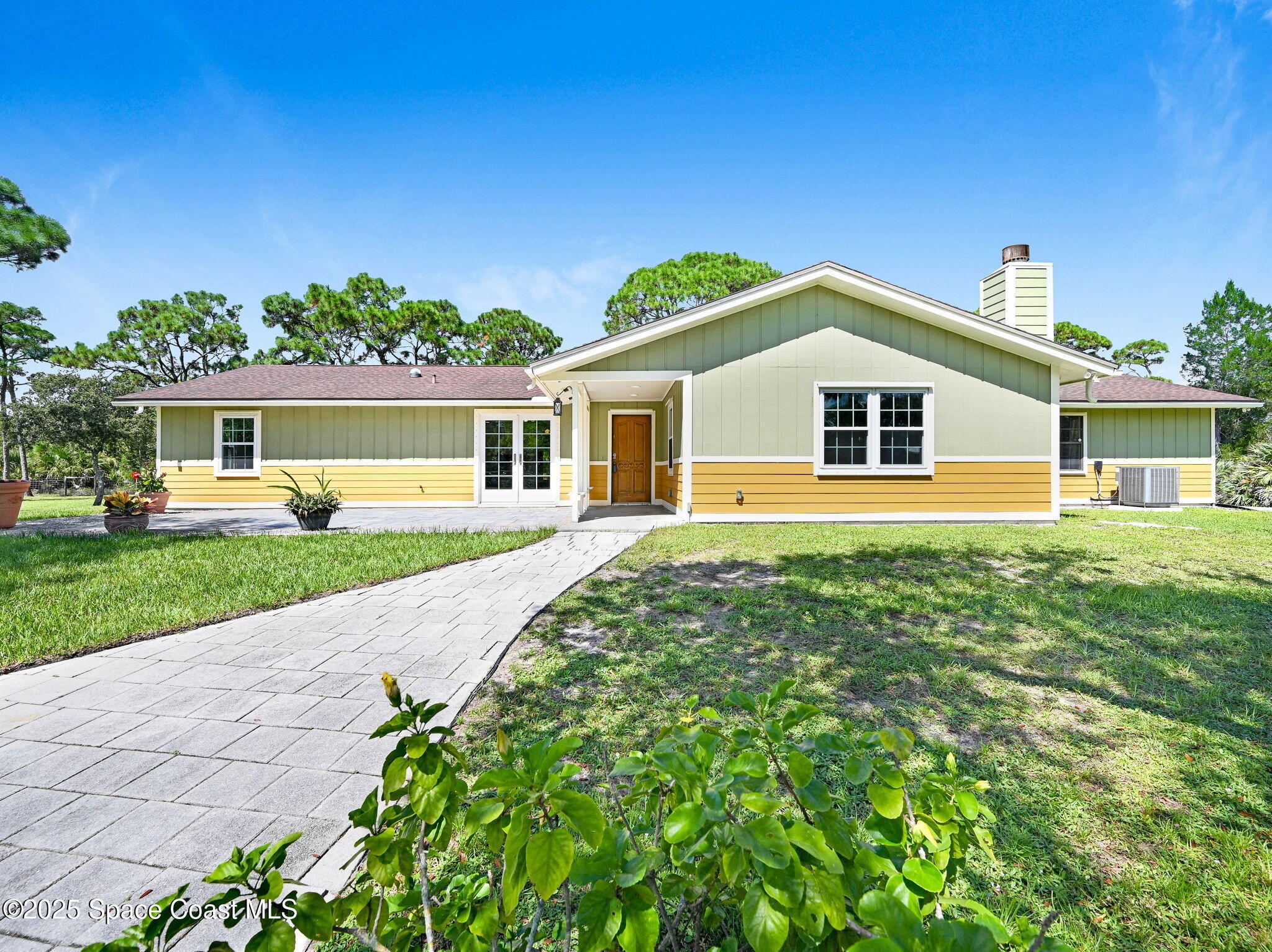 6570 Whispering Pines Lane Grant, FL 32949 - Photo 60 of 62 a front view of a house with garden