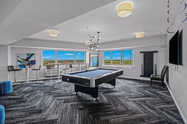 a living room with furniture a flat screen tv and kitchen view