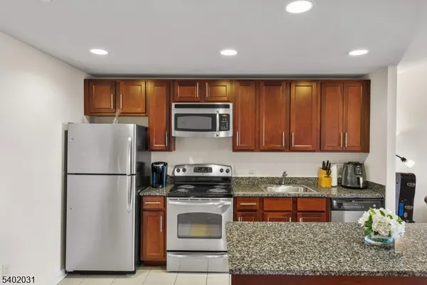 a kitchen with a refrigerator and a stove top oven