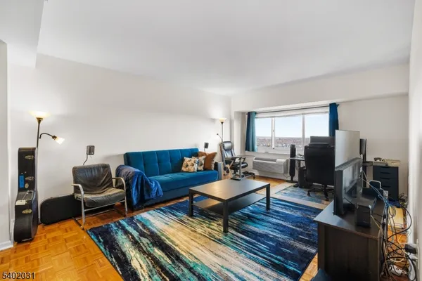a living room with furniture a flat screen tv and a rug