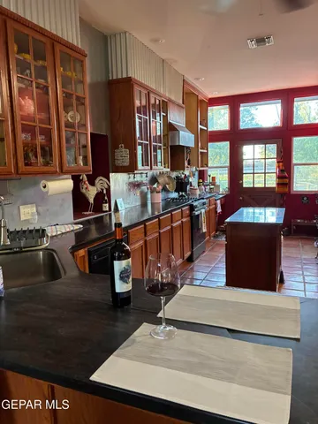 a kitchen with stainless steel appliances kitchen island granite countertop a refrigerator and a stove