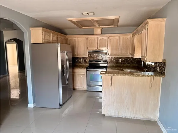 a kitchen with stainless steel appliances a refrigerator a stove a microwave and cabinets