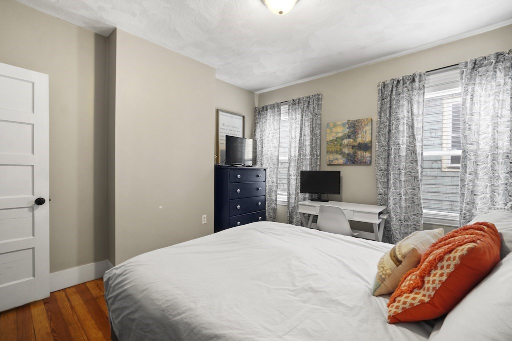 155 Boston Street, Unit 3 Boston, MA 02125 - Photo 15 of 15 a bedroom with a bed and a flat tv screen