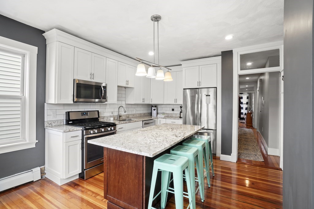 155 Boston Street, Unit 3 Boston, MA 02125 - Photo 2 of 15 a kitchen with stainless steel appliances granite countertop a stove refrigerator and microwave