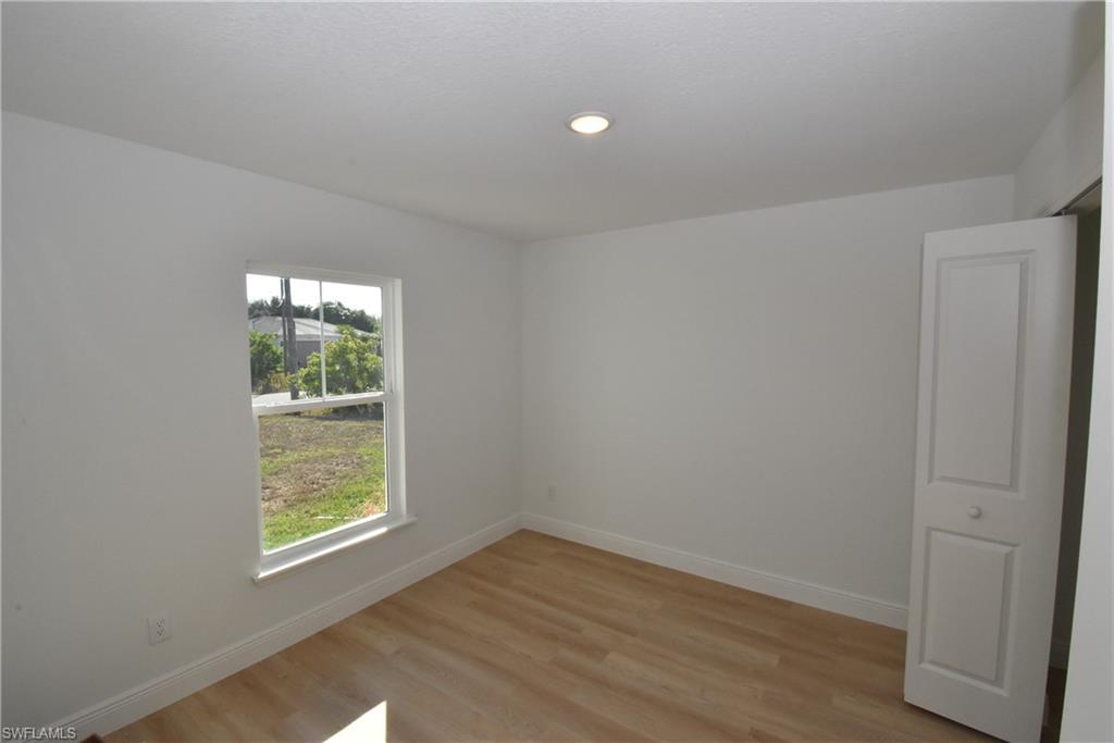5051 Foxhall Road North Port, FL 34288 - Photo 24 of 27 an empty room with wooden floor and windows