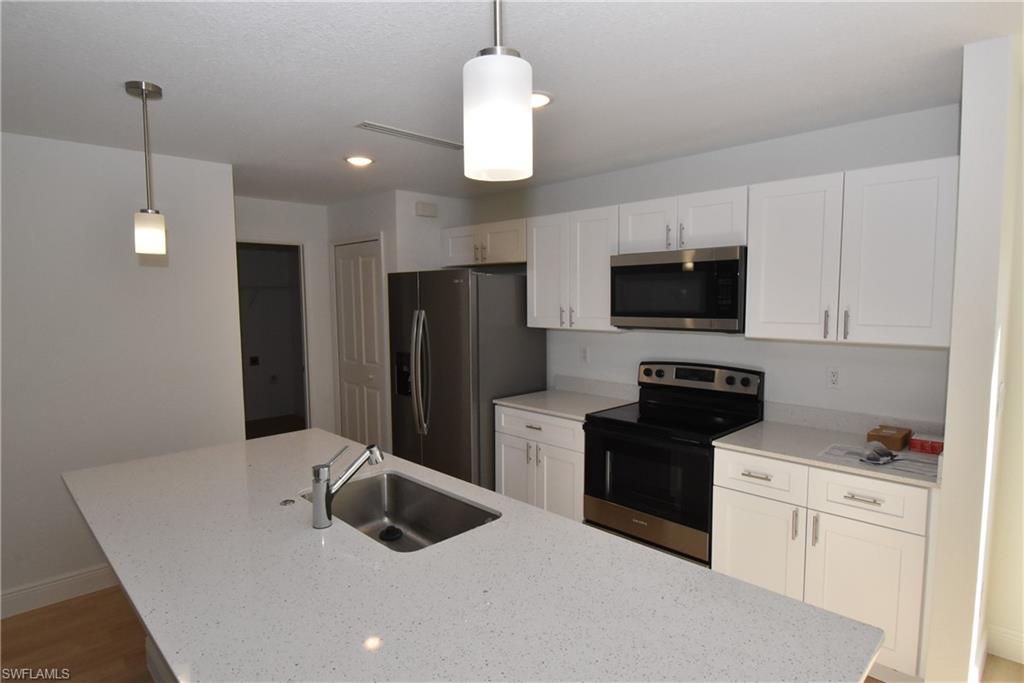 5051 Foxhall Road North Port, FL 34288 - Photo 3 of 27 a kitchen with stainless steel appliances granite countertop a refrigerator a stove a sink and a microwave