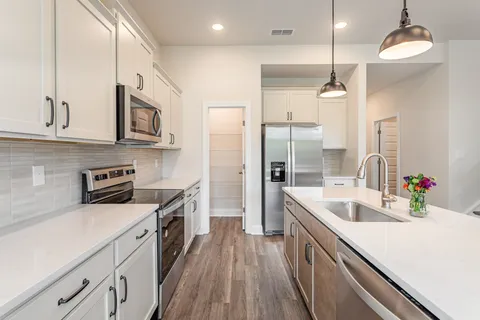 an open kitchen with a sink and stove top oven
