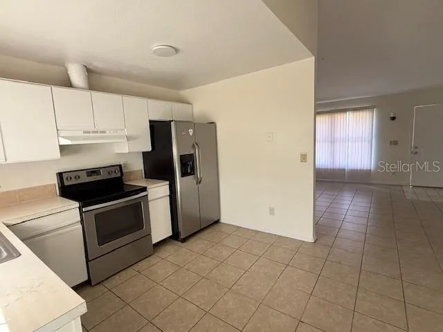 a kitchen with a refrigerator sink and cabinets