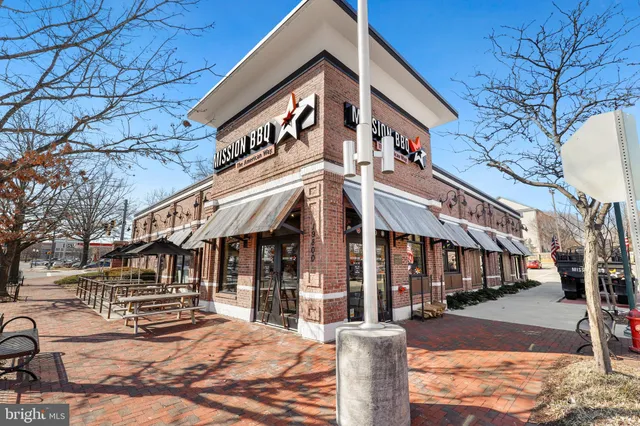 a front view of a building with cars parked