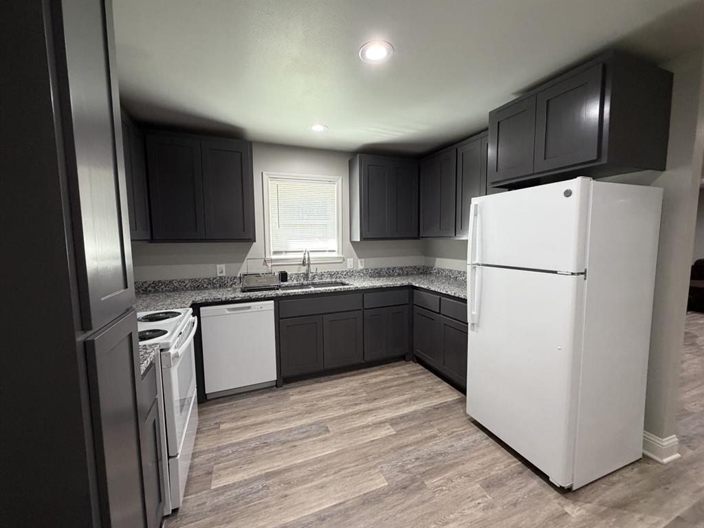 118 Carolyn Street Mansfield, LA 71052 - Photo 18 of 26 a kitchen with a refrigerator a microwave a sink and cabinets