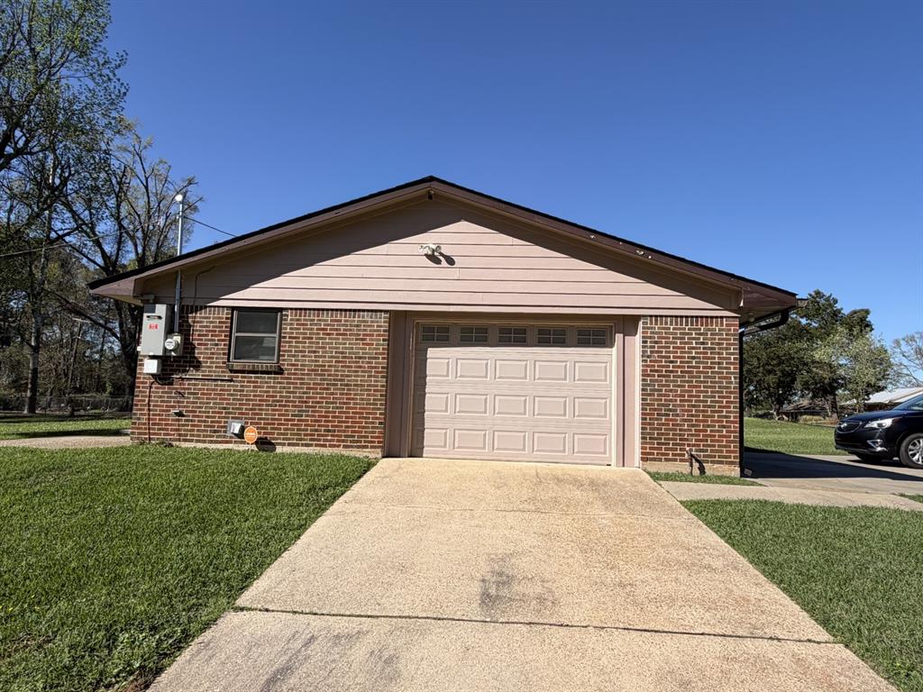 118 Carolyn Street Mansfield, LA 71052 - Photo 7 of 26 a front view of a house with a yard and garage