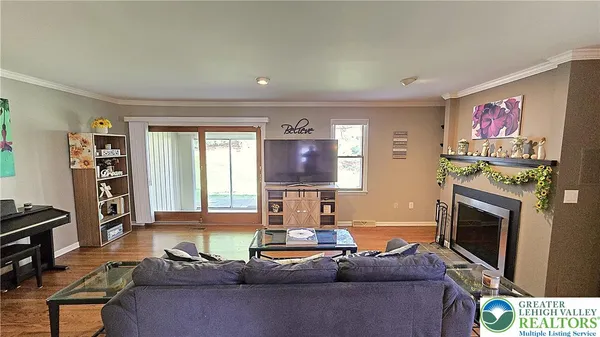 a living room with furniture a flat screen tv and a fireplace
