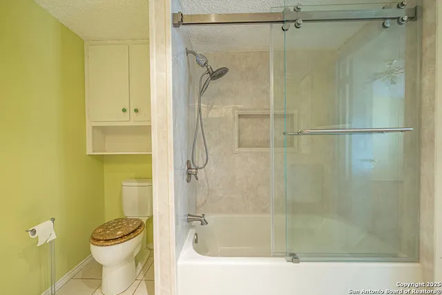 a bathroom with a granite countertop sink a toilet a mirror and shower