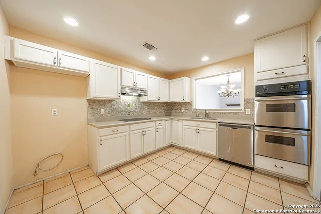 a kitchen with a sink window and cabinets
