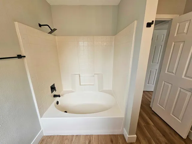 a bathroom with a white tub a sink and a mirror