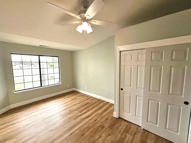 an empty room with wooden floor and window