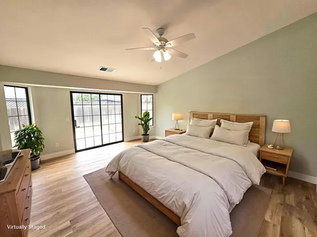 a spacious bedroom with a large bed and a chandelier