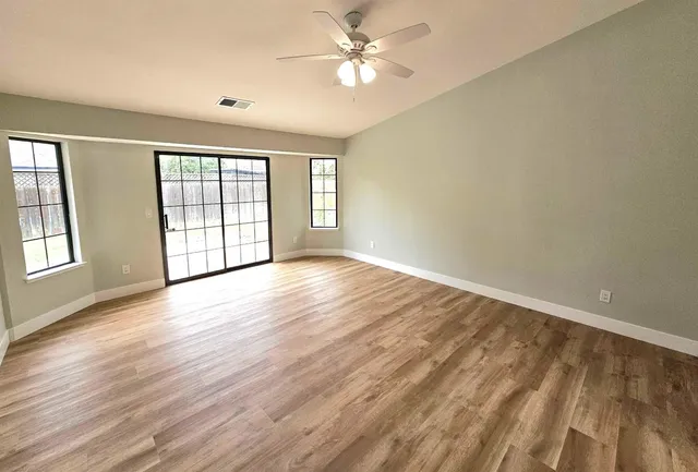 wooden floor in an empty room with a window