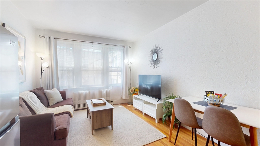 90 Kilsyth Road, Unit 43 Boston, MA 02135 - Photo 3 of 8 a living room with furniture and a flat screen tv
