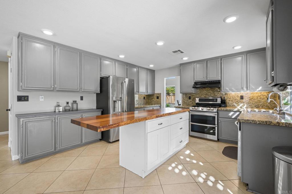 13675 Stonybrook Lane El Cajon, CA 92021 - Photo 12 of 34 a kitchen with stainless steel appliances granite countertop a refrigerator and a stove top oven