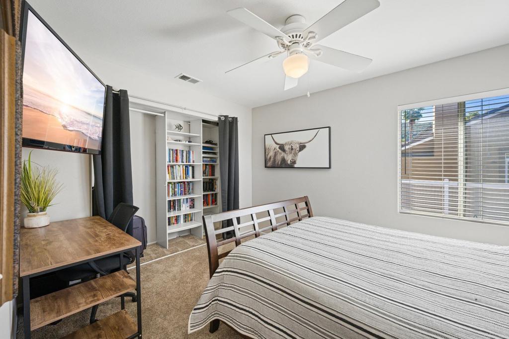 13675 Stonybrook Lane El Cajon, CA 92021 - Photo 14 of 34 a bedroom with a bed a large window and book self