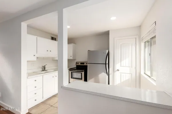a kitchen with granite countertop white cabinets and stainless steel appliances