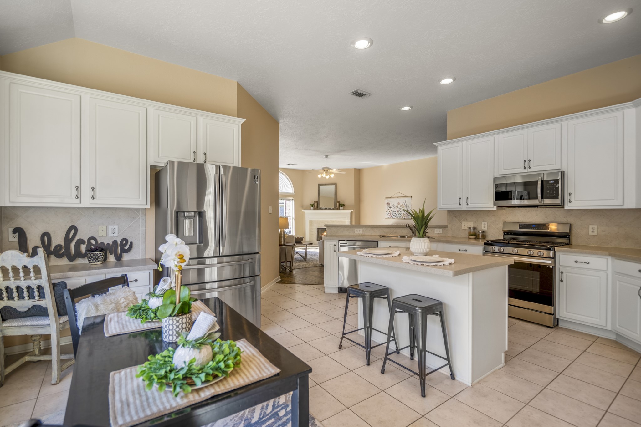 21107 Coldde Meadow Lane Spring, TX 77379 - Photo 18 of 50 a kitchen with stainless steel appliances kitchen island granite countertop a refrigerator a stove a sink a dining table and chairs with wooden floor