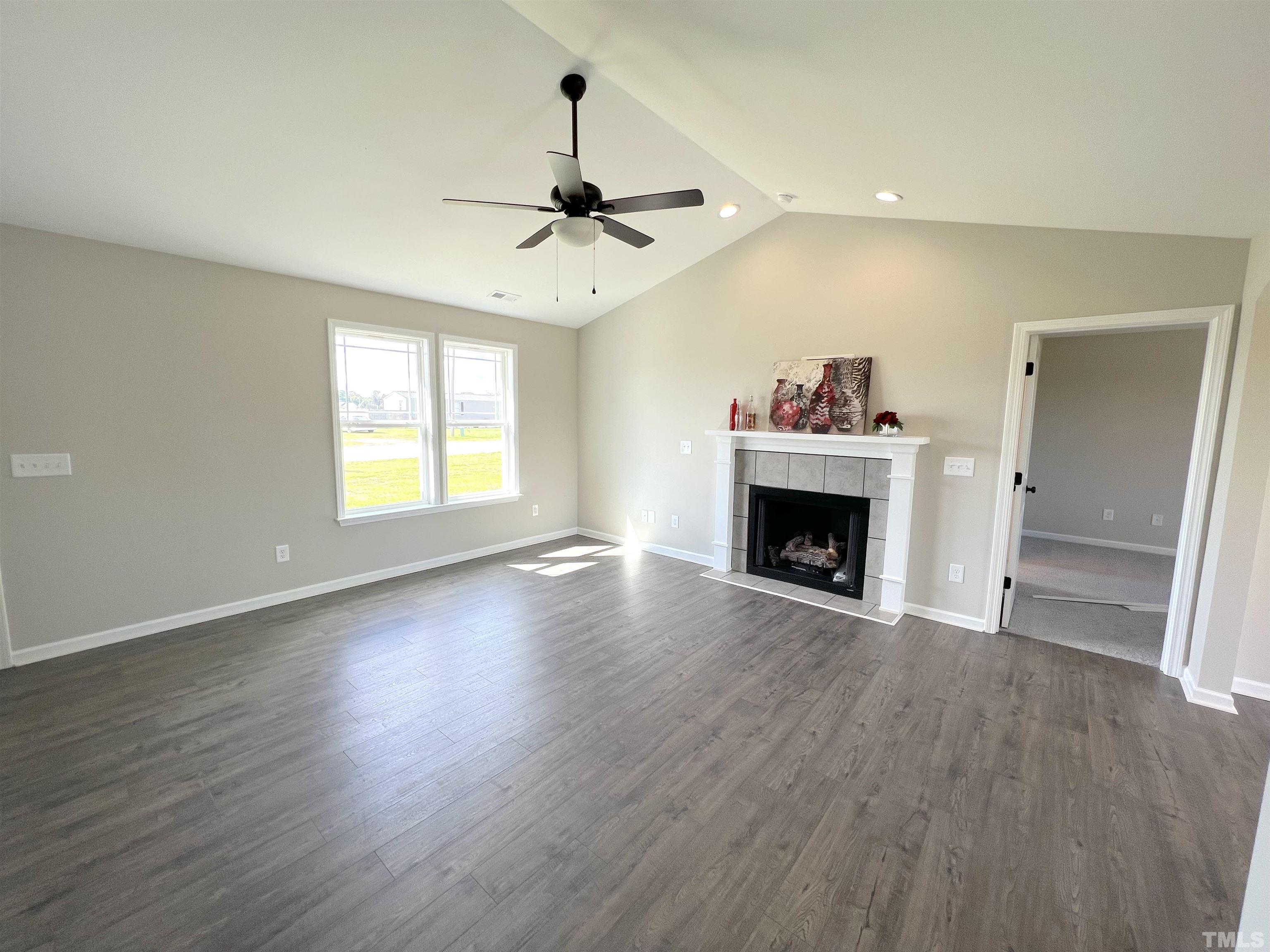 111 Adds Road Pikeville, NC 27863 - Photo 5 of 23 an empty room with windows fireplace and wooden floor