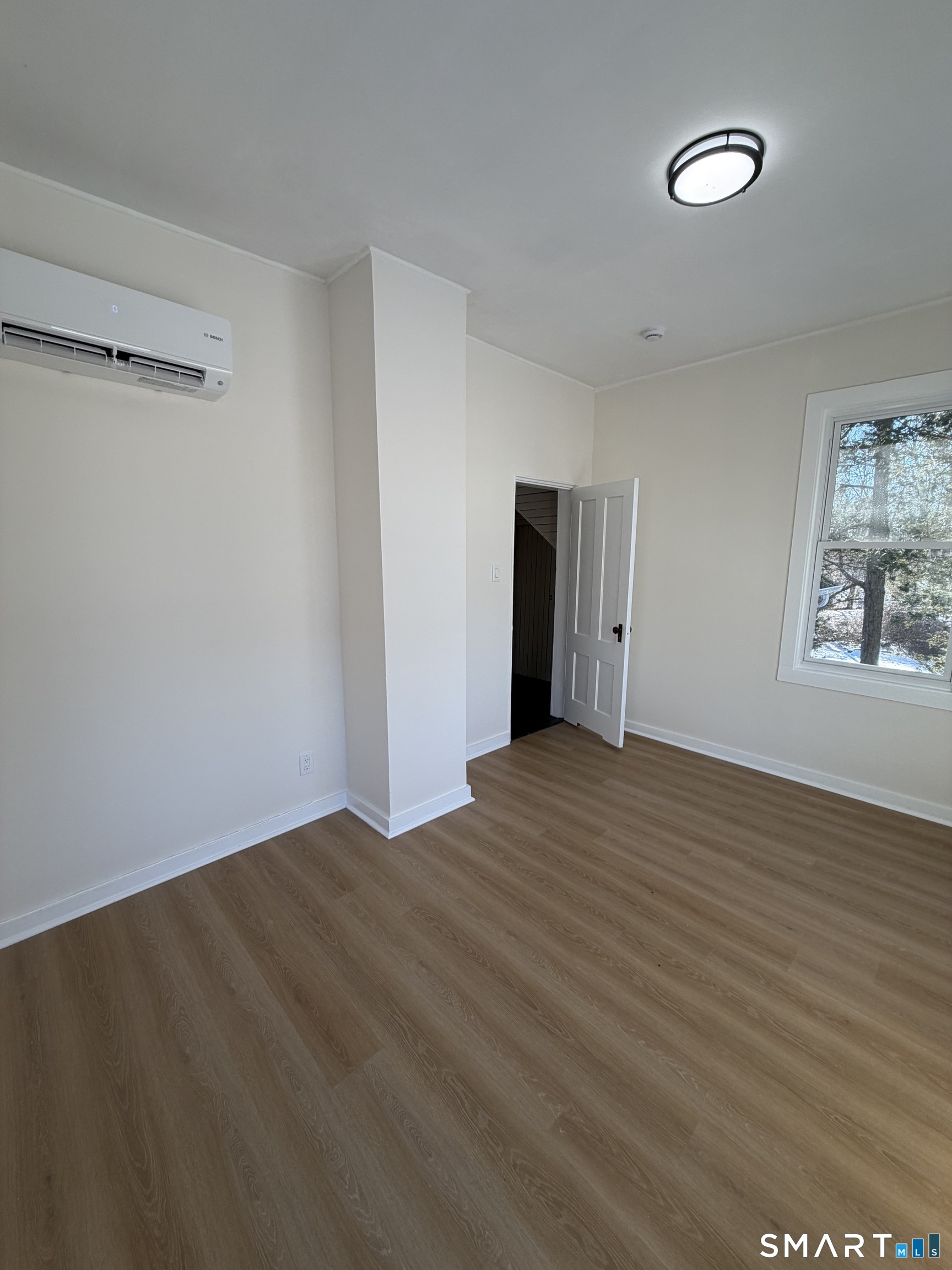 473 Amity Road Woodbridge, CT 06525 - Photo 13 of 16 a view of an empty room with wooden floor and a window