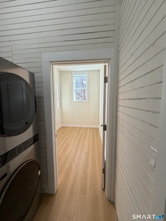 a view of a hallway with wooden floor and staircase