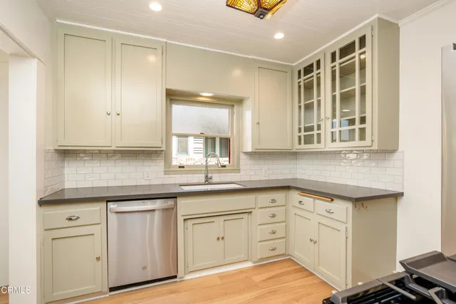 a kitchen with white cabinets and sink